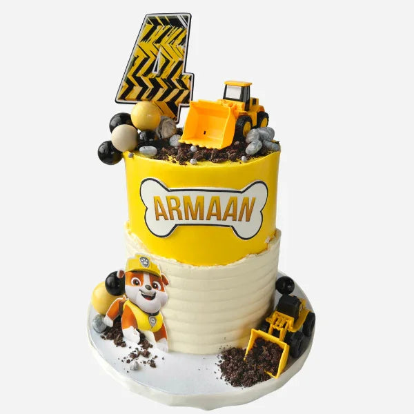 Construction-themed birthday cake with bulldozer, traffic sign, and character figure on a white background