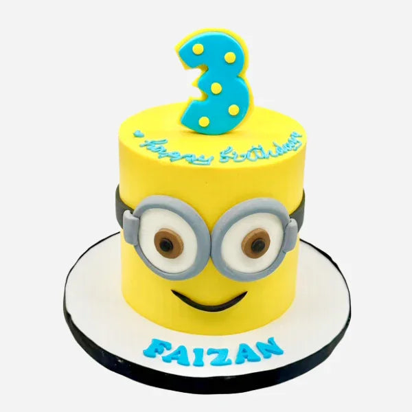Yellow Minion birthday cake with a number 3 and the name 'Faizan' on a white background